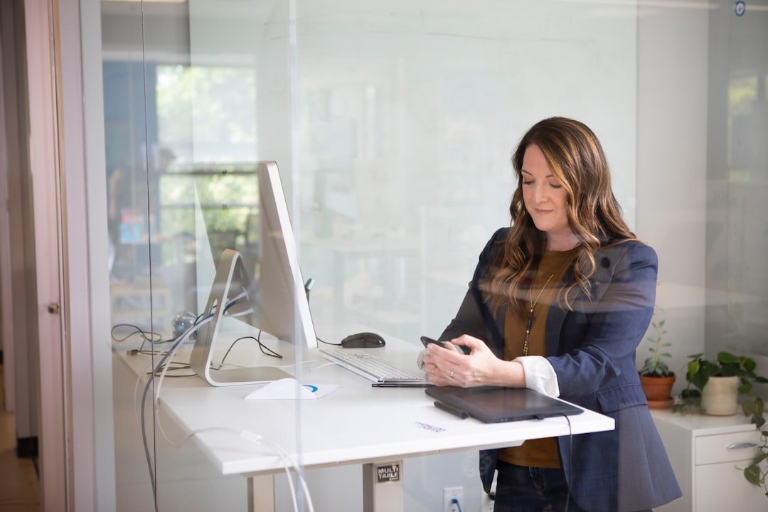 Media professional working at a desk with phone and computer